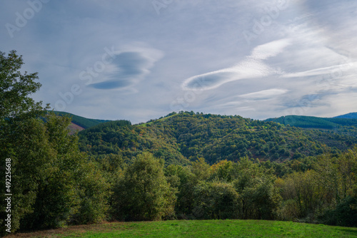 Lenticular clouds on a windy day over the mountains and forests