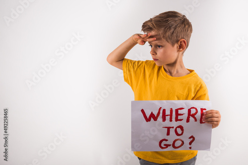 A child with paper Where to go?  Boy depression and anxiety . Sadness longing hope. Children's tears from the war. Evacuation of civilians. Freedom to Ukraine. Little boy looking where to go after war