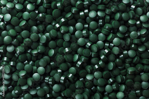 Dark Green round tablets of organic spirulina as a texture photo