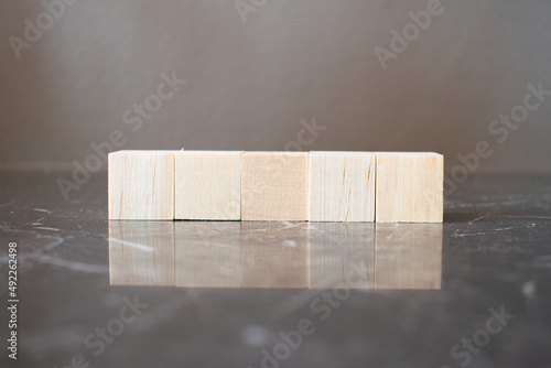 Fototapeta Naklejka Na Ścianę i Meble -  Tower of four wooden cubes on neutral background with copy space