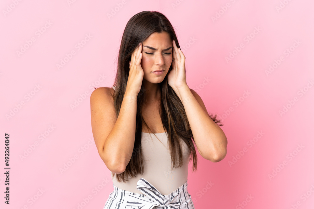 Young brazilian woman isolated on pink background with headache Young brazilian woman isolated on pink background with headache