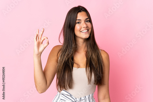 Young brazilian woman isolated on pink background showing ok sign with fingers