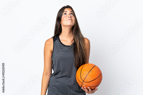 Young brazilian woman playing basketball isolated on white background and looking up © luismolinero
