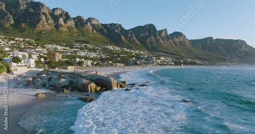 Epic aerial close-up panning view of Camps Bay beach,Lion's Head and 12 Apostles mountain range in background,Cape Town, South Africa photo