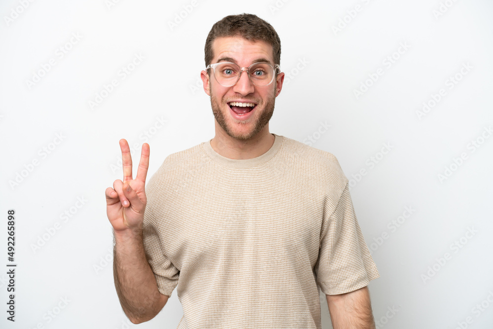 Young caucasian man isolated on white background smiling and showing victory sign Young caucasian man isolated on white background smiling and showing victory sign