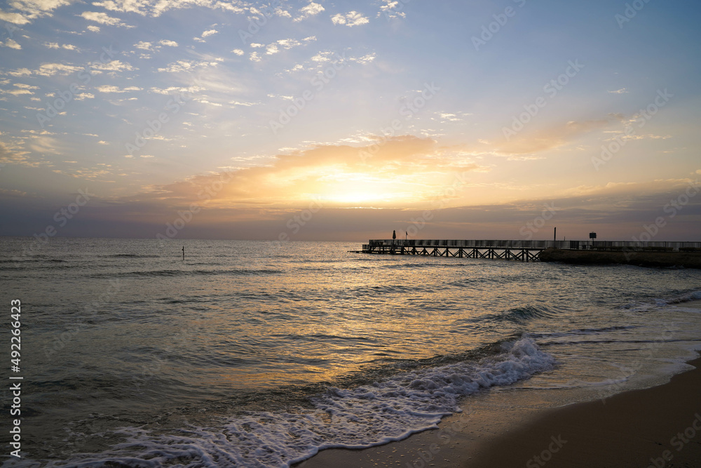Beautiful sunrise over the ocean with a footbridge in Makadi Bay, Egypt