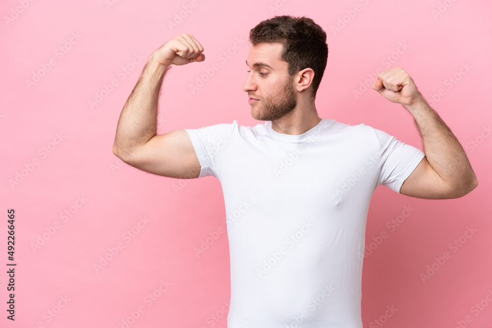Young caucasian man isolated on pink background doing strong gesture Young caucasian man isolated on pink background doing strong gesture