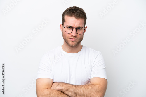 Young caucasian man isolated on white background With glasses and arms crossed