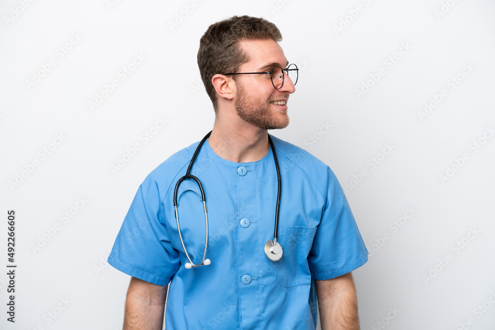 Young surgeon doctor caucasian man isolated on white background looking side Young surgeon doctor caucasian man isolated on white background looking side