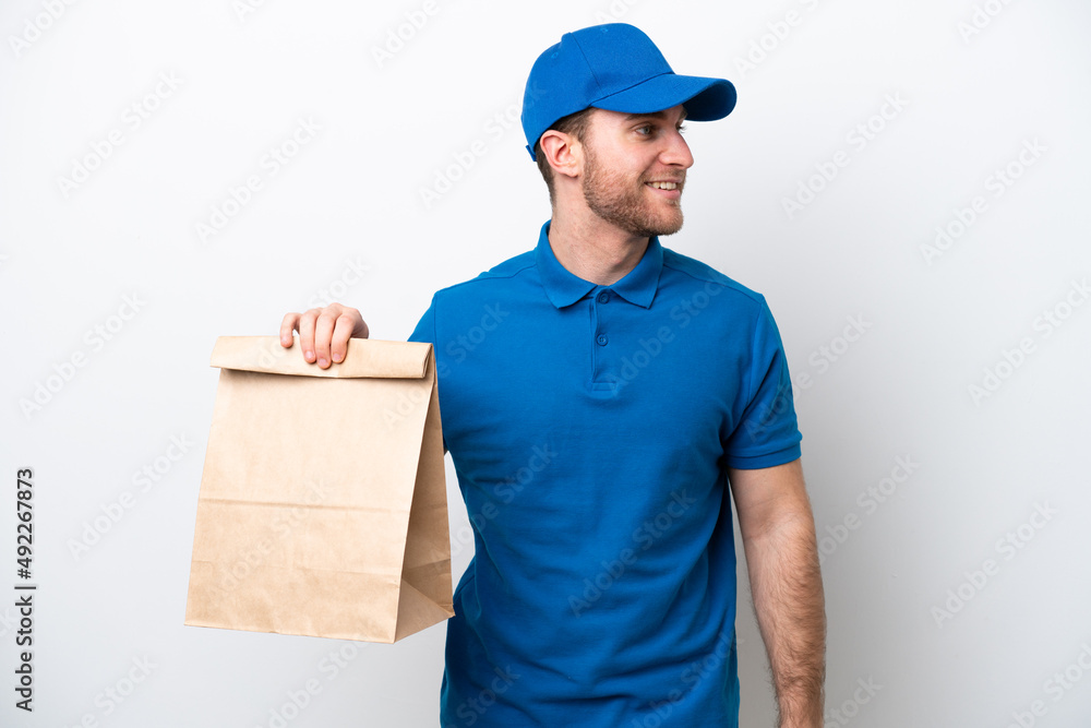 Delivery caucasian man isolated on white background looking side