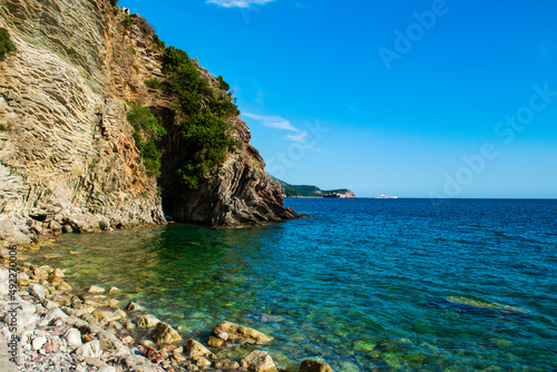 Fototapeta Naklejka Na Ścianę i Meble -  Beautiful rocks on pebble public stone beach. Rafailovici esort towns. Mountenegro. Adriatic Sea.