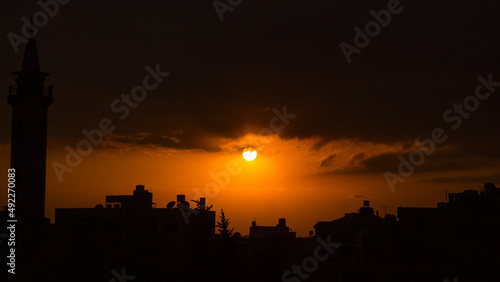 Dramatic Dark Orange Sunset Behind Over Buildings in city