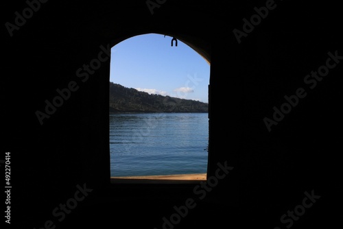 Window of a castle looking to the sea and the montains.