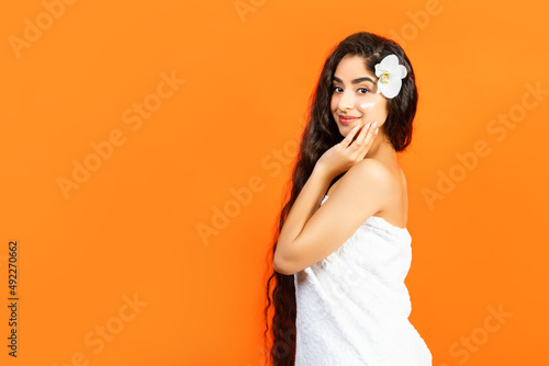 Canvas-taulu Spa and Wellness background with a beautiful mixed race woman with healthy long hair and cream on her cheek