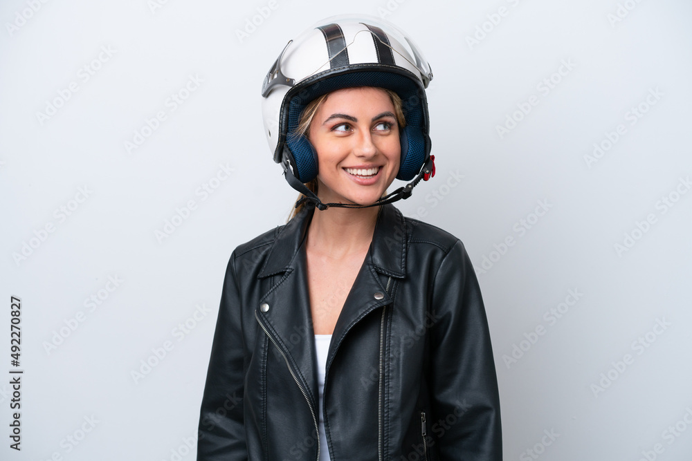 Young caucasian woman with a motorcycle helmet isolated on white background looking side Young caucasian woman with a motorcycle helmet isolated on white background looking side