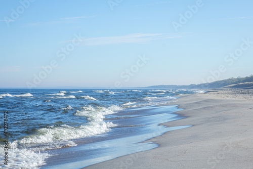 Seascape, the photo shows a sunny day, waves and sand