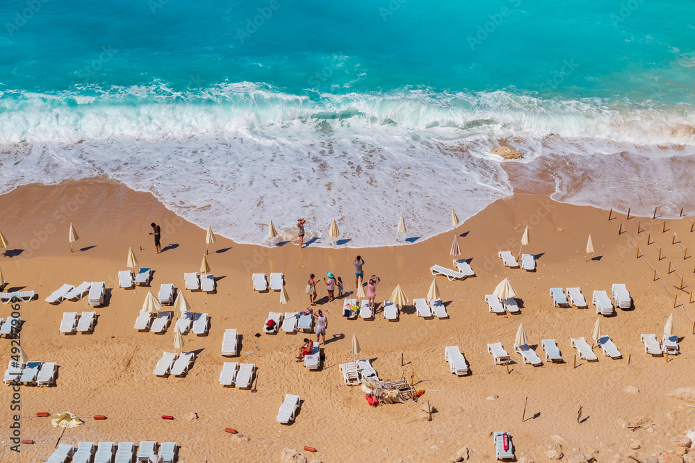 Aerial View From Flying Drone Of People Crowd Relaxing On Beach. Swimming people in sea. Top view of Kaputas Beach between Kas and Kalkan Aerial View From Flying Drone Of People Crowd Relaxing On Beach. Swimming people in sea. Top view of Kaputas Beach between Kas and Kalkan