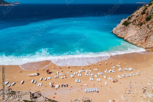 Aerial View From Flying Drone Of People Crowd Relaxing On Beach. Swimming people in sea. Top view of Kaputas Beach between Kas and Kalkan