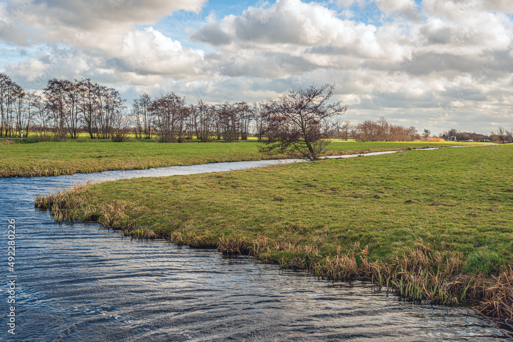 Typical Dutch polder landscape on a stormy day. The photo was taken on a cloudy winter day near the village of Ouderkerk aan den IJssel in the province of South Holland.