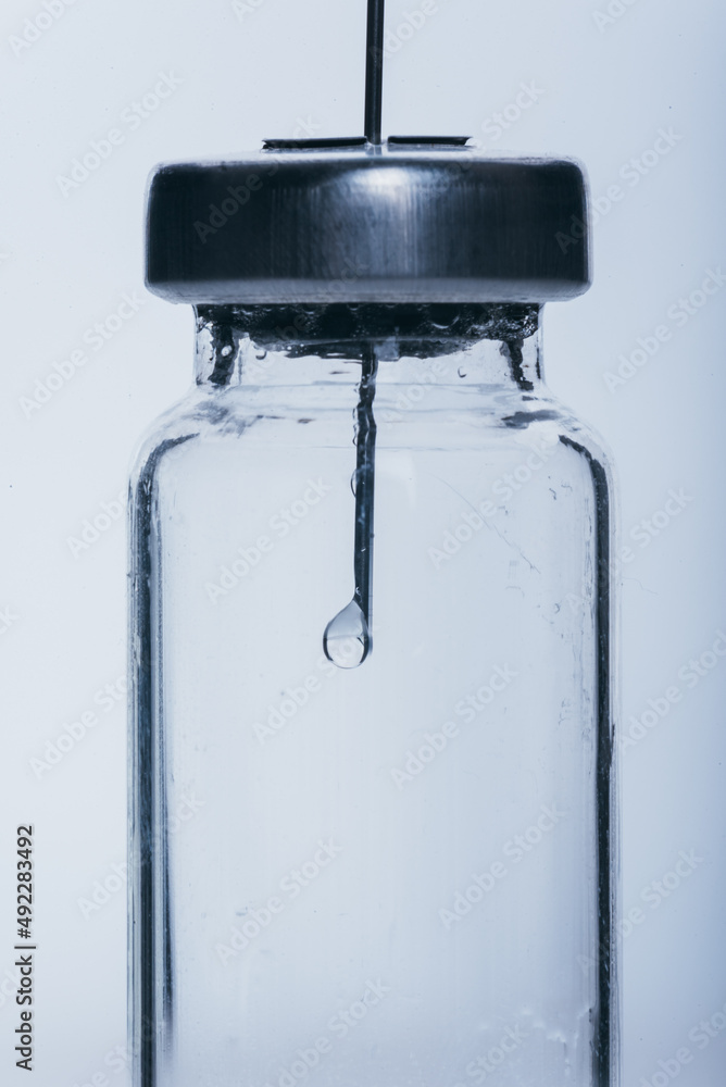 Medicine, Injection, vaccine and disposable syringe, drug concept. Sterile vial medical syringe needle. Macro close up. Glass medical ampoule vial for injection. Bottles ampule with aluminum cap.