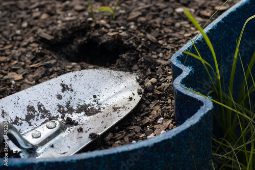 a trowel gardening tool in a garden pot on earth day with dirt and plants