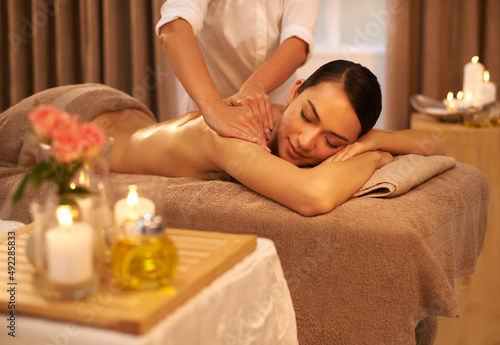 Indulging her senses at the spa. A beautiful young woman enjoying a massage at the spa.