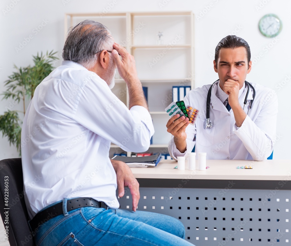 Obraz premium Old man visiting young male doctor