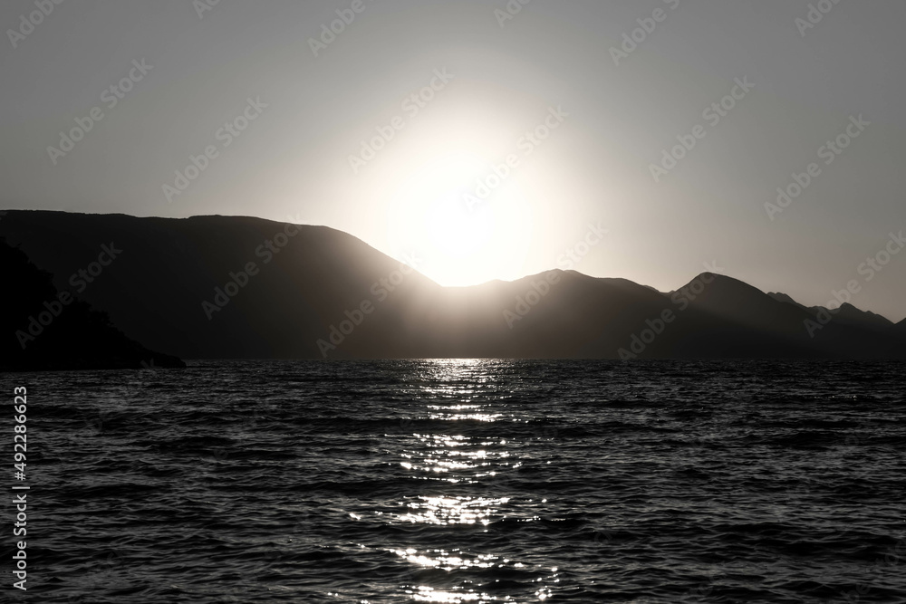 the outline of the mountains at sunset, the shore of the adriatic sea in croatia, summer sunset by the sea, black and white