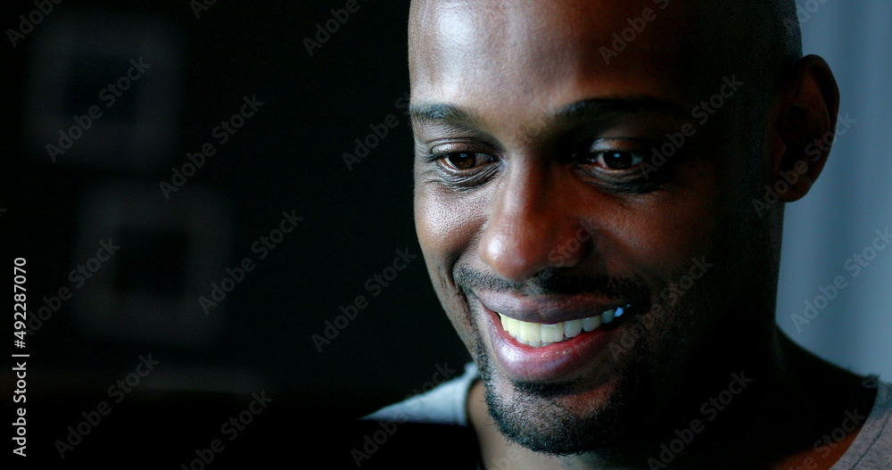 Close-up black man face looking at computer screen at night Close-up black man face looking at computer screen at night