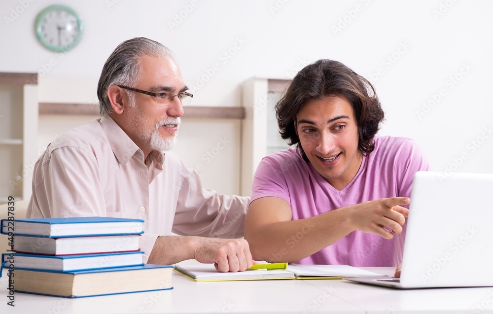 Old father helping his son in exam preparation Old father helping his son in exam preparation