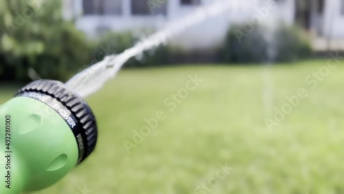 Watering the grass. The grass are watered. Watering the grass in the garden.