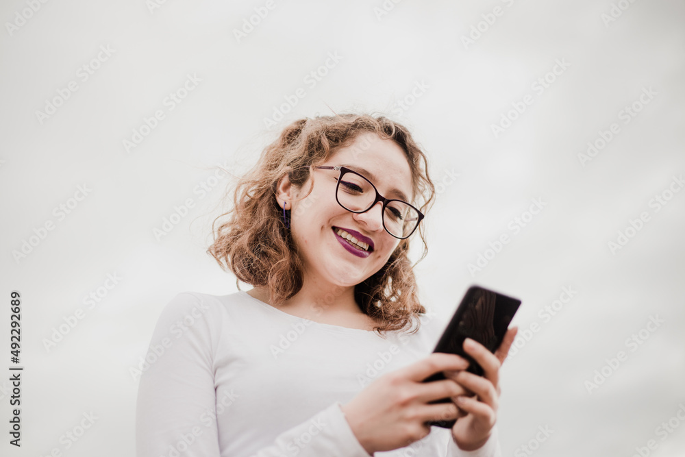 Mujer con lentes usando su celular. Concepto de telefonía. Mujer con lentes usando su celular. Concepto de telefonía.