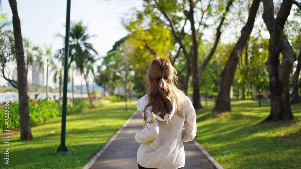 Confidence Asian woman in sportswear jogging exercise at city public park in summer morning. Healthy wellness female athlete enjoy outdoor lifestyle activity sport training fitness running workout Confidence Asian woman in sportswear jogging exercise at city public park in summer morning. Healthy wellness female athlete enjoy outdoor lifestyle activity sport training fitness running workout