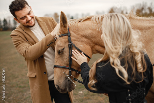 Romantic couple with a brown horse in the field