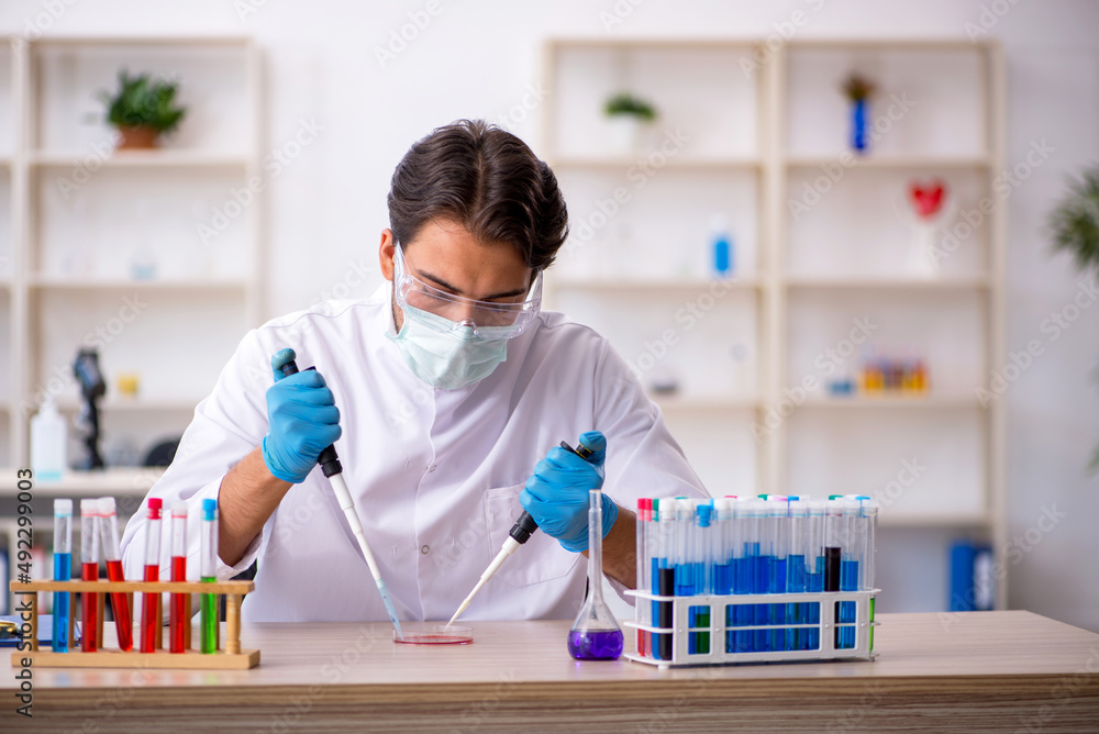 Young male chemist working at the lab Young male chemist working at the lab