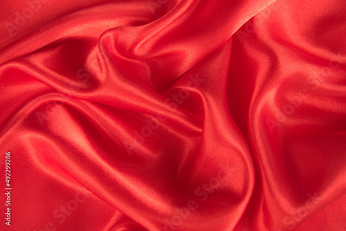 Abstract red silk fabric texture background. Cloth soft wave.