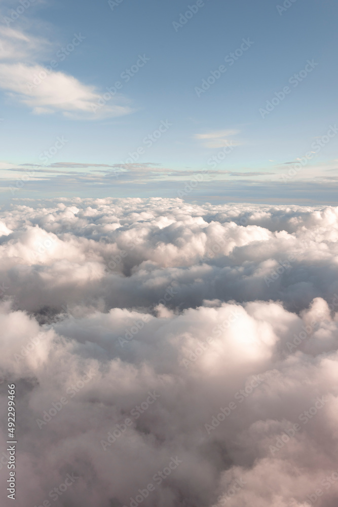 View across fluffy clouds and a blue sky View across fluffy clouds and a blue sky