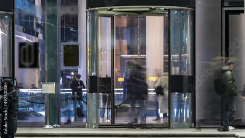 The flow of people passing through the rotating door of the modern office building at the end of the working day,time lapse