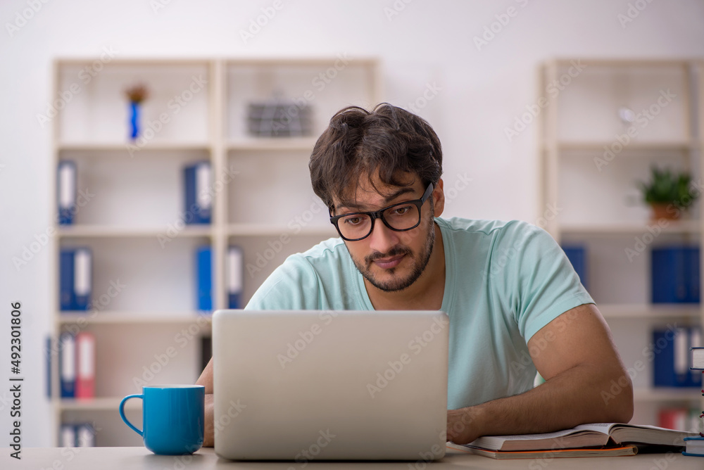 Young male student preparing for exams in the classroom Young male student preparing for exams in the classroom