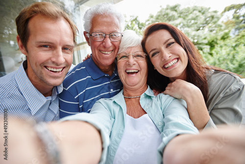 The generation of selfies. Cropped shot of four adults taking a family selfie.