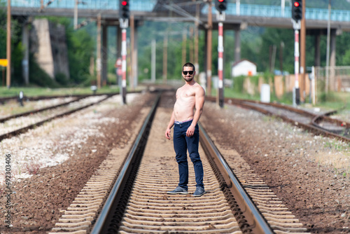 Man Showing His Stomach Outdoors at Railroad © Jale Ibrak