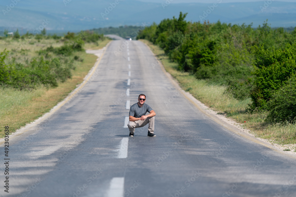 Portrait of Muscular Man Crouching Outdoors at Highway