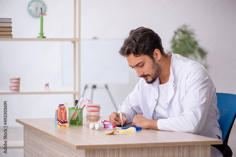 Young male dentist working in the clinic Young male dentist working in the clinic