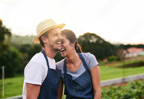 Having a blast working together. Cropped shot of an affectionate young couple laughing while working on their privately owned farm.