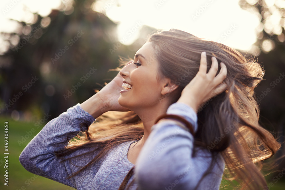 This is what it means to be alive. A carefree young woman flinging her hair while outdoors. This is what it means to be alive. A carefree young woman flinging her hair while outdoors.