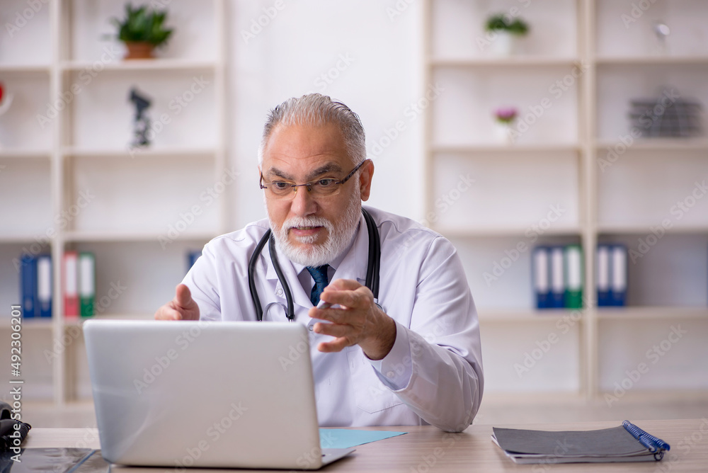 Old male doctor in telemedicine concept Old male doctor in telemedicine concept