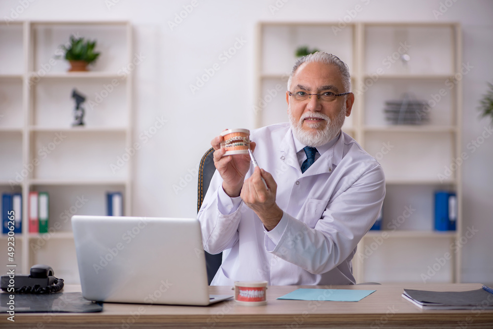 Old male doctor dentist working in the clinic Old male doctor dentist working in the clinic
