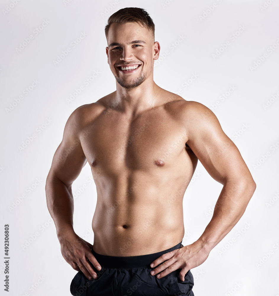 This is the body that dedication gets you. Shot of a muscular young man posing against a white background.