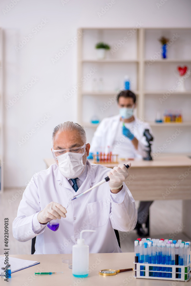 Two male chemist working at the lab Two male chemist working at the lab