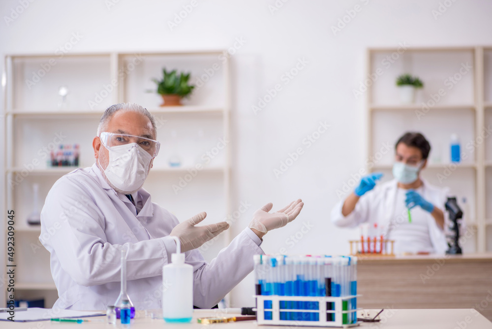 Two male chemist working at the lab Two male chemist working at the lab